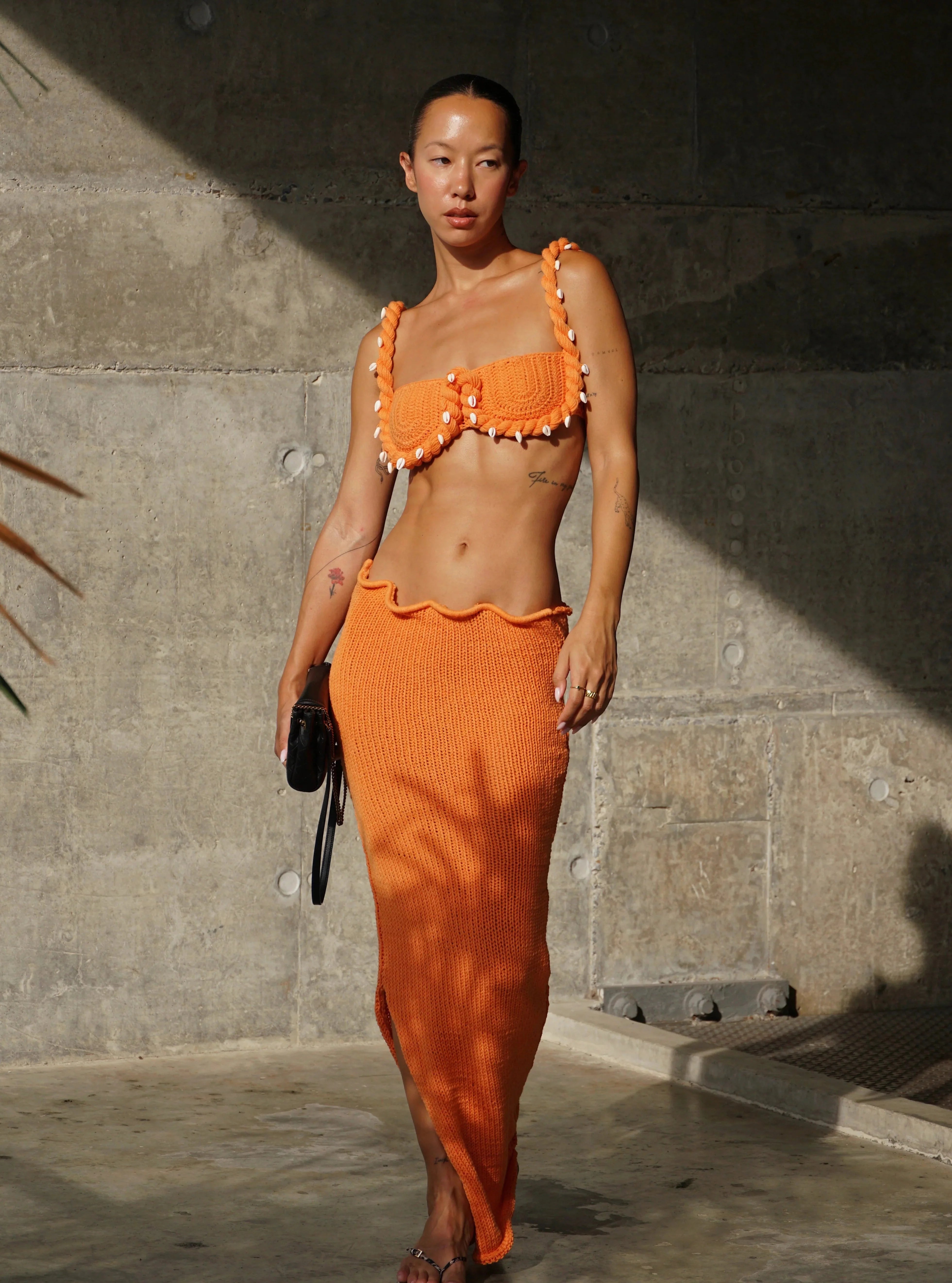 Conjunto tejido naranja Aumare en la playa