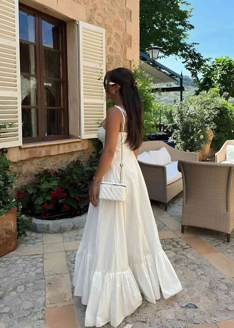Mujer caminando en la playa con vestido Aumare Èze blanco